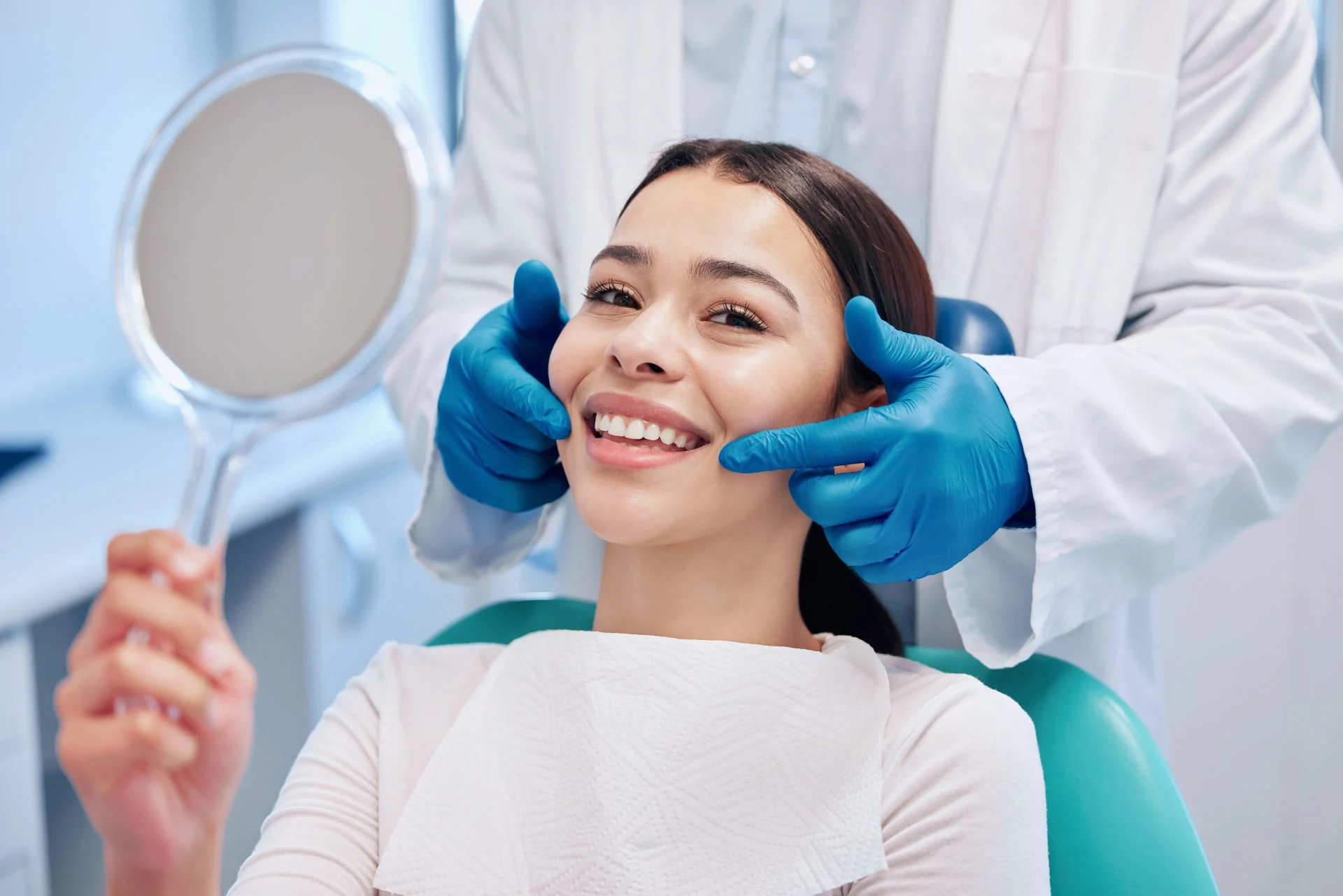 a young woman checking her teeth result in the dentists office.